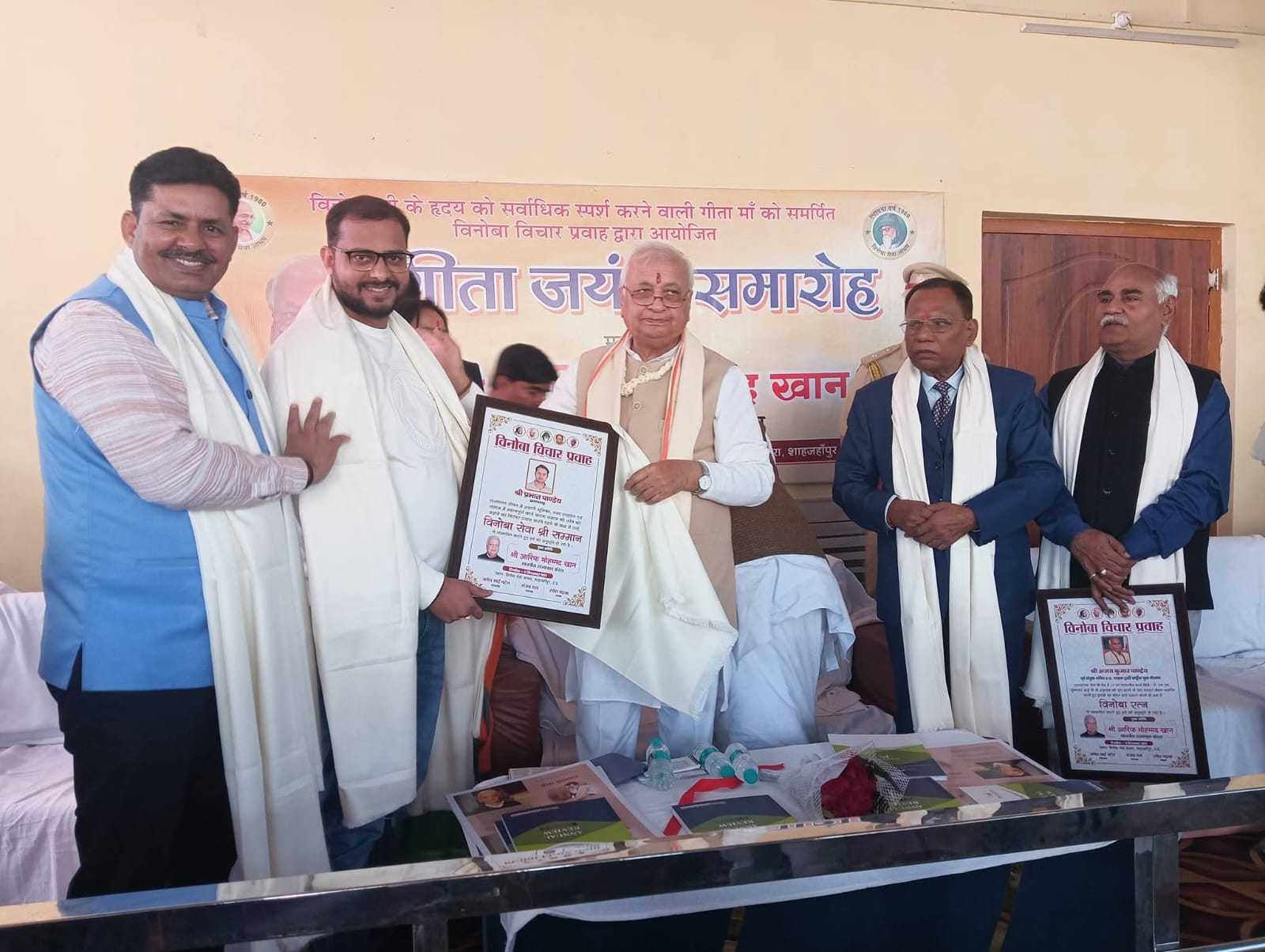 Participants holding framed certificates at a recognition ceremony