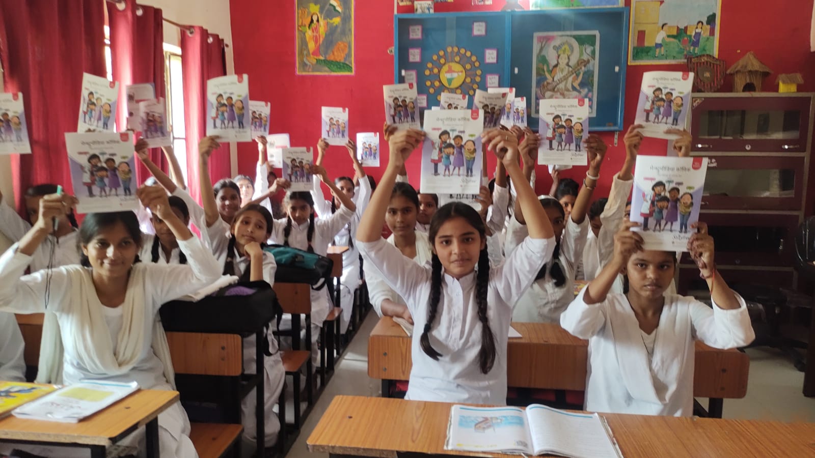 Students holding learning booklets in a classroom